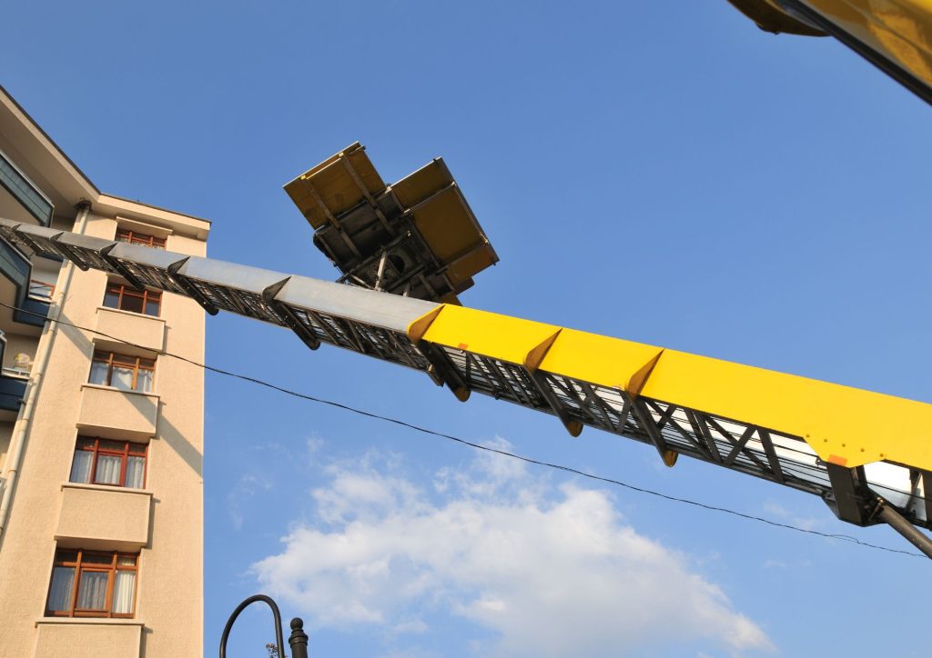 Grúa elevadora transportando cajas hacía el balcón de una casa